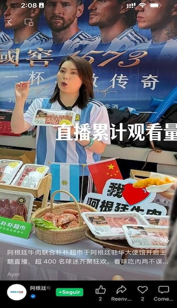 Mujer china con camiseta argentina con carne argentina e imagen de la selección de fútbol de fondo