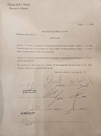 Primer plano de un dictamen del Senado de la Nación, con texto impreso y múltiples firmas autógrafas de senadores, fechado el 13 de mayo de 2026