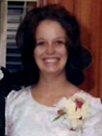 Retrato de Hilma Witte sonriendo con el cabello oscuro peinado con volumen y un vestido blanco con un adorno floral en el hombro