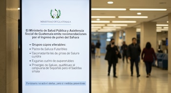 Panel digital vertical con el escudo de Guatemala y texto del Ministerio de Salud sobre recomendaciones por polvo del Sahara; personas borrosas al fondo.