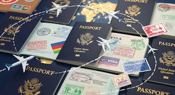 Vista superior de múltiples pasaportes, algunos abiertos mostrando sellos y visas, con aviones de juguete y líneas punteadas sobre un mapa mundial.