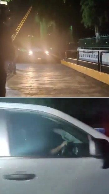 Un vehículo blanco sale de una cerca de seguridad por la noche y en la parte inferior se observa una camioneta en movimiento