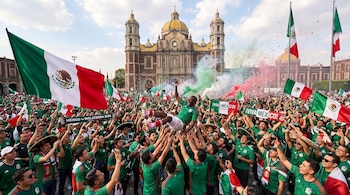Multitud de personas con camisetas verdes celebra con banderas de México, confeti y humo de colores. Un hombre es levantado. Basílica de Guadalupe al fondo.