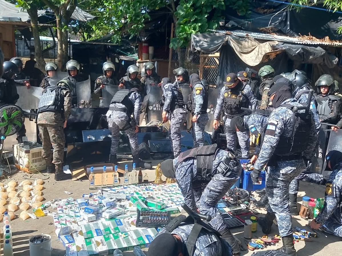 Un grupo de agentes policiales y militares inspecciona una gran cantidad de productos confiscados (Sistema Penitenciario de Guatemala)