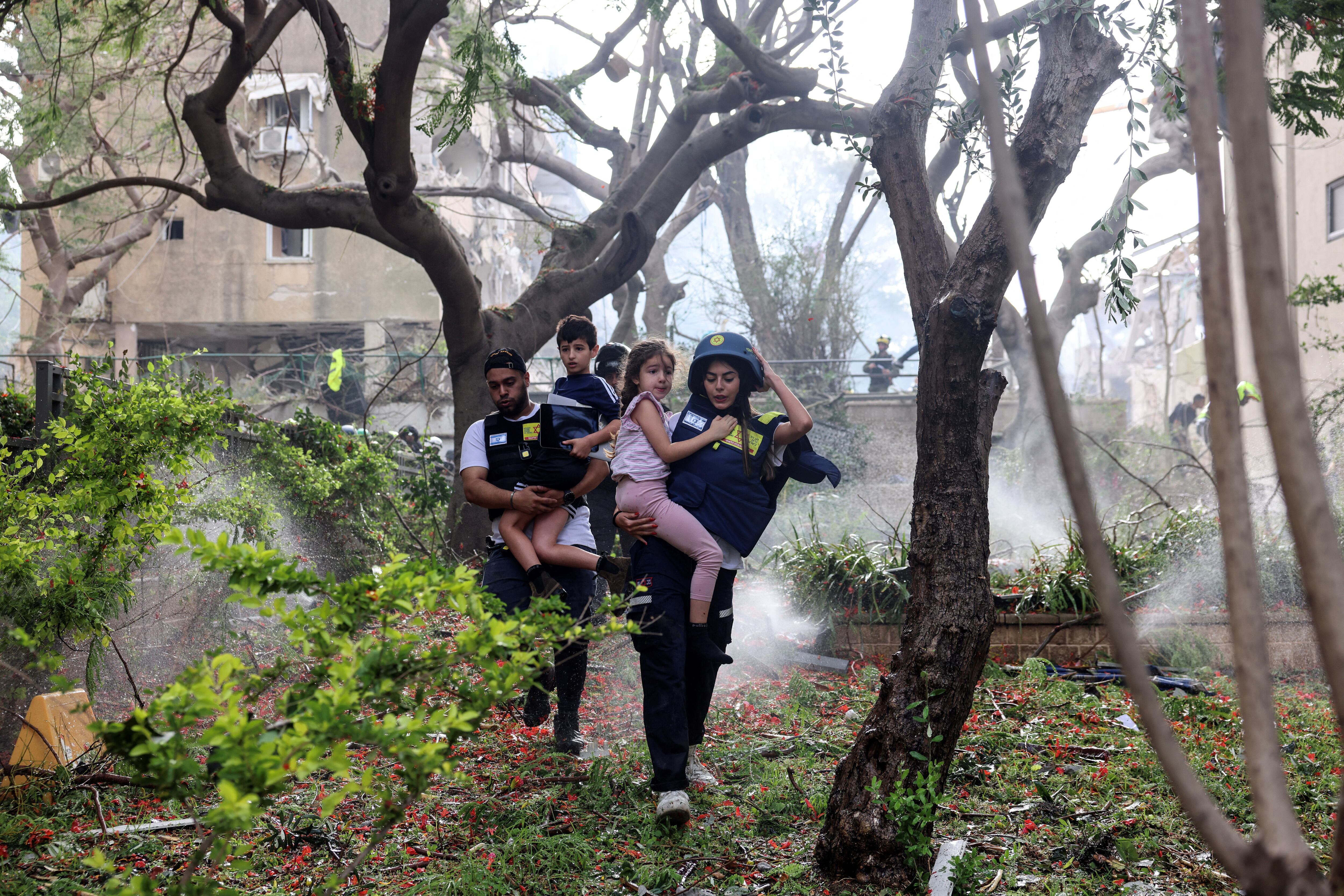 Bomberos israelíes rescatan a dos chico en Tel Aviv, tras el ataque aéreo ejecutado por el regimen iraní
