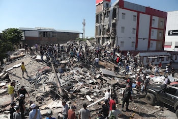Residentes y equipos de rescate buscan entre los escombros de un edificio derrumbado tras el terremoto que azotó Cali, Colombia, el lunes 10 de agosto de 2026. (AP Foto/Santiago Saldarriaga)