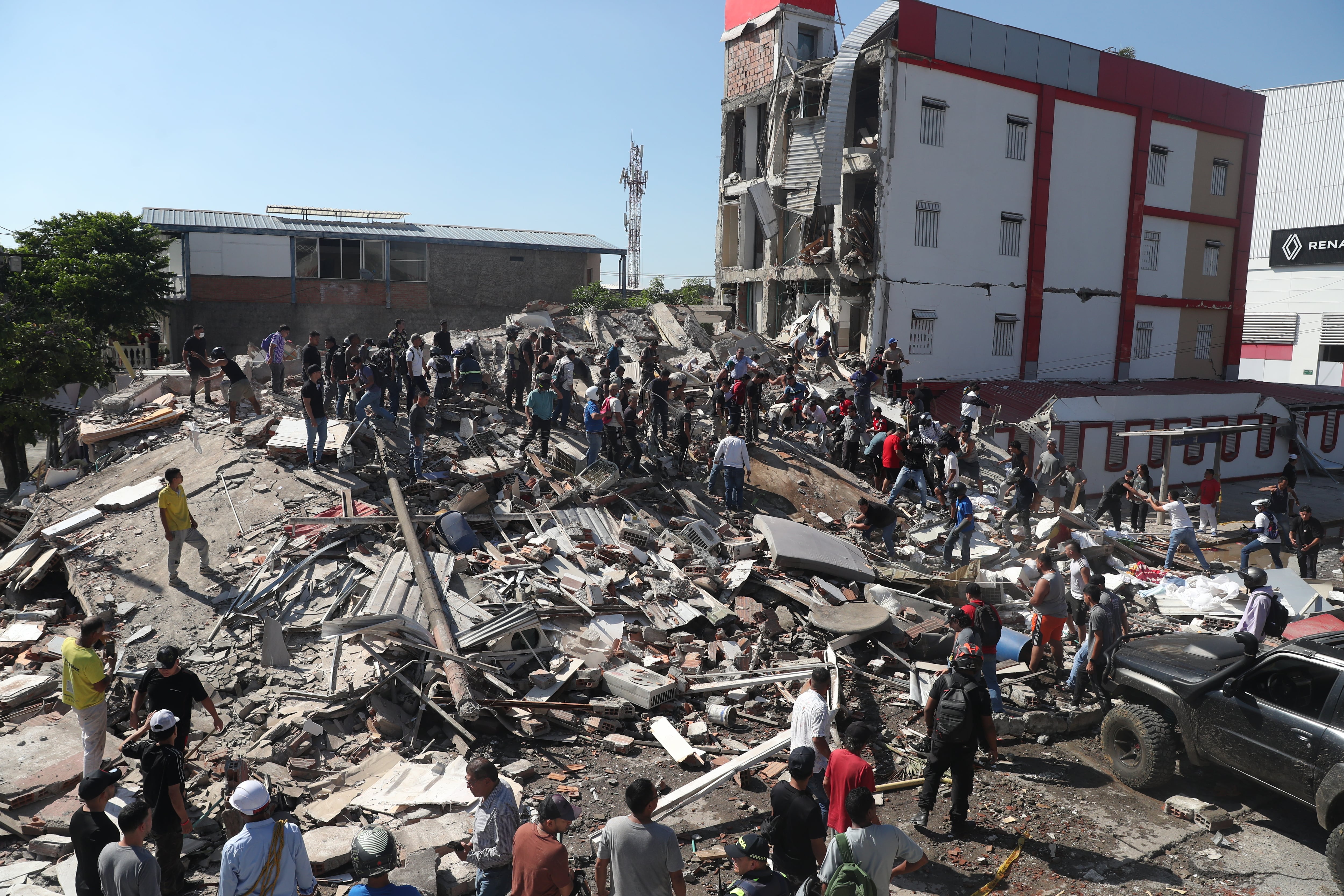 Residentes y equipos de rescate buscan entre los escombros de un edificio derrumbado tras el terremoto que azotó Cali, Colombia, el lunes 10 de agosto de 2026. (AP Foto/Santiago Saldarriaga)