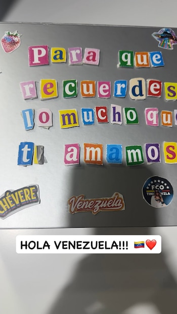 Una superficie gris con letras recortadas pegadas en fila, calcomanías alusivas a Venezuela y una etiqueta inferior con texto y emoticonos