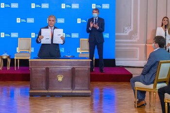 Iván Duque posa con el decreto que fija el nuevo salario mínimo para los trabajadores en Colombia ($1.000.000 mensuales). Foto: EFE/Presidencia