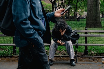 Joven con su celular, cerca de Washington Square Park en la Universidad de Nueva York (Shuran Huang para The Washington Post)