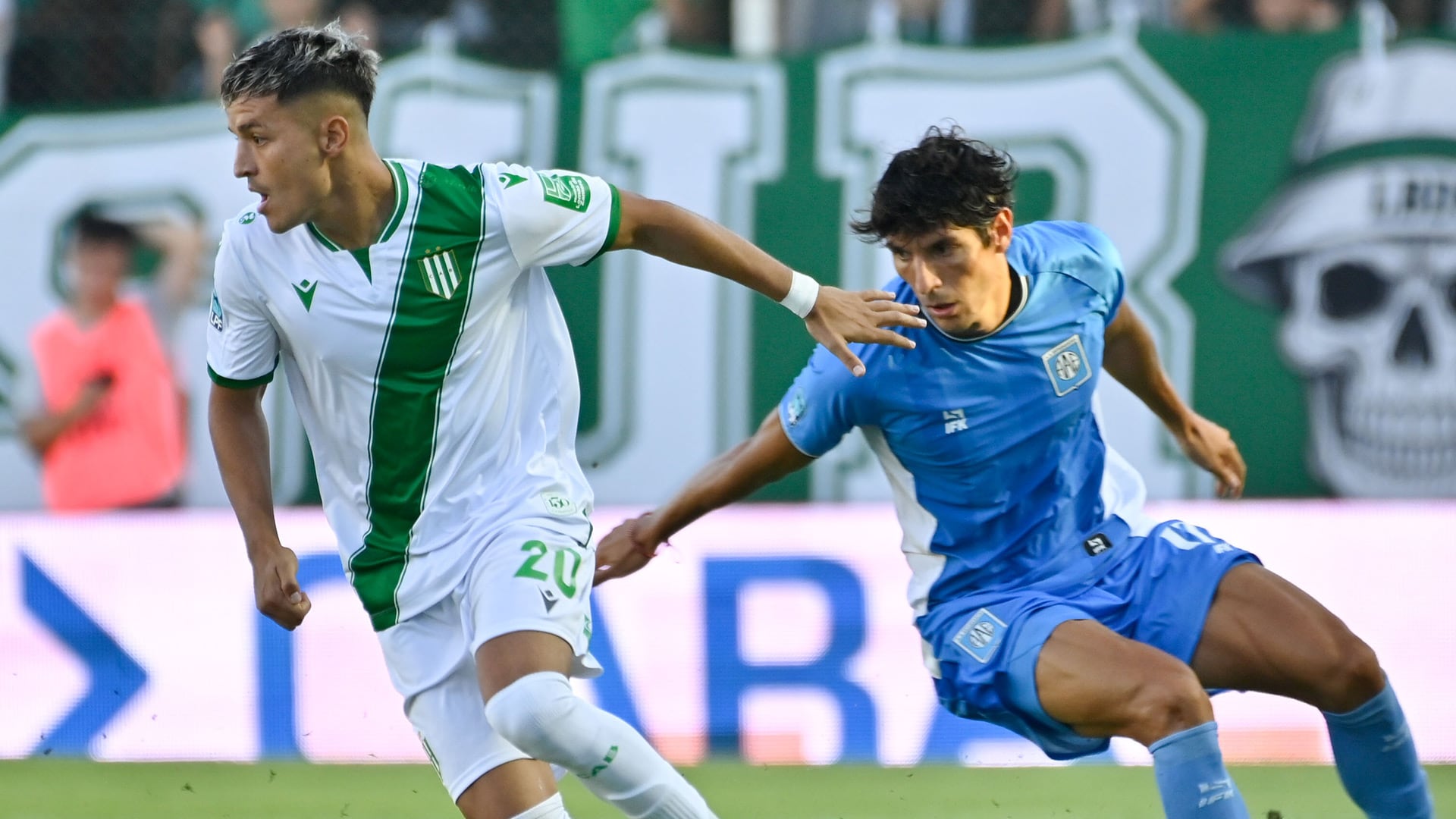 Dos jugadores de Banfield y Estudiantes de Río Cuarto compiten intensamente por el balón en un partido de la Liga Profesional (Fotobaires)