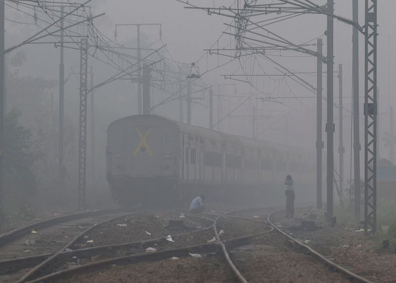 Unos hombres esperan en una vía férrea el paso de un tren, en una mañana de niebla tóxica en Nueva Delhi
November 13, 2024. REUTERS/Anushree Fadnavis