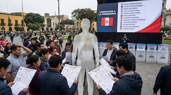 Uma grande multidão observa a votação para o Peru 2026. Silhueta de um candidato em frente a uma tela com uma lista e uma bandeira peruana. Ânforas ONPE ao fundo.