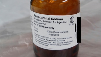 Un frasco de vidrio ámbar con una etiqueta blanca en inglés que indica Pentobarbital Sodium solución para inyección