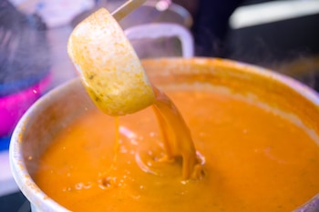 Cocineras y vendedores del mercado ofrecieron la sopa recién servida, mostrando la textura característica del caldo, resultado de horas de cocción y el uso del tradicional “relajo” de especias. (Foto cortesía Alcaldía de San Salvador)