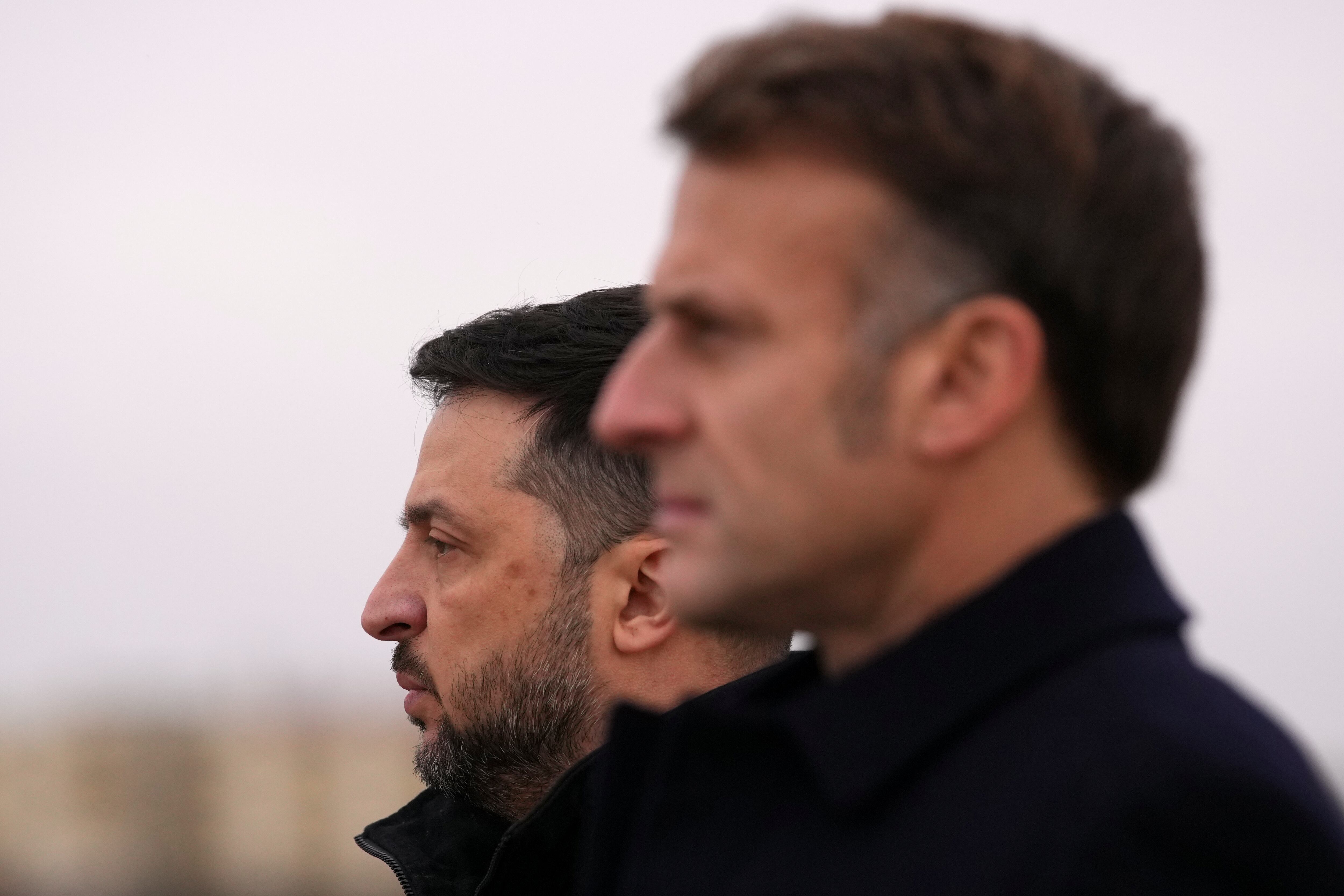El presidente francés Emmanuel Macron (derecha) y el presidente ucraniano Volodimir Zelensky escuchan los himnos nacionales el lunes 17 de noviembre de 2025 en la base aérea de Villacoublay, cerca de París. (Foto AP/Christophe Ena, Pool)