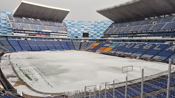 Vista panorámica del interior del Estadio Cuauhtémoc en Puebla, con el campo de fútbol y la pista de atletismo completamente cubiertos de granizo blanco