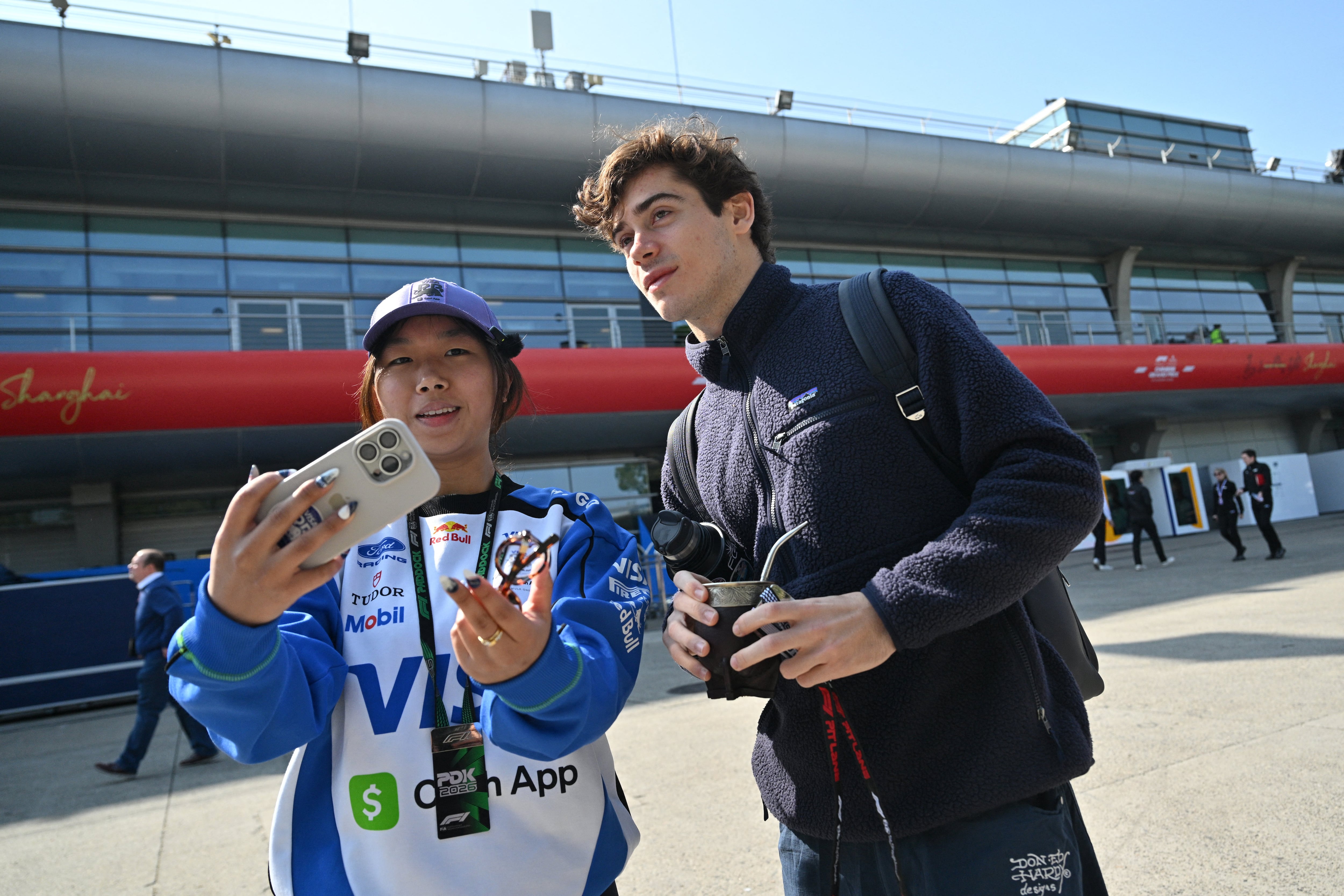 El piloto argentino junto a una fanática en el circuito de Shanghai (Photo by Hector RETAMAL / AFP)