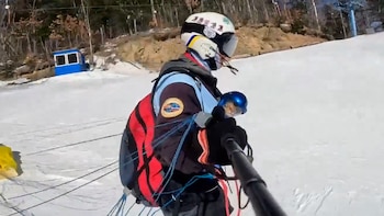 Un gato salta en paracaídas para esquiar y se coloca un pequeño casco.