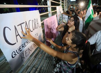 Mujeres colocan una pancarta que