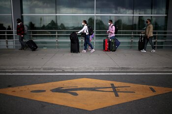 Passengers wearing face masks line