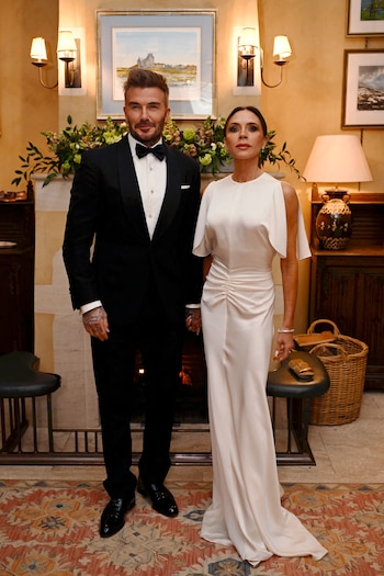 El vestido blanco satinado con mangas abiertas resalta la pureza y luminosidad de los tejidos acompañados por joyas y clutch dorados (REUTERS)