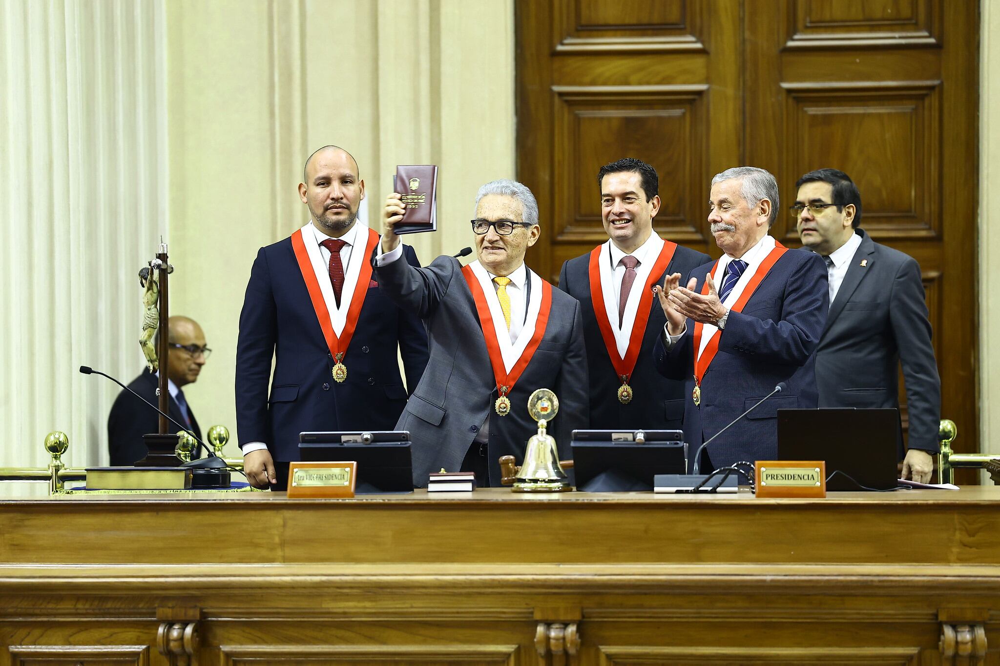 Alejandro Aguinaga, con un libro en alto, jura su cargo como senador para el periodo 2026-2031 junto a otros funcionarios en una ceremonia. (Flickr / Congreso de la República)