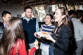 Los feligreses ríen con sus amigos en el Pizza Box antes de dirigirse a la misa católica en la iglesia de San José en Nueva York. (Brian Anselm/Para The Washington Post)