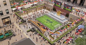 Vista aérea de un Fan Village en Rockefeller Center con un campo de fútbol, pantallas mostrando un partido, una fuente, banderas internacionales y gente