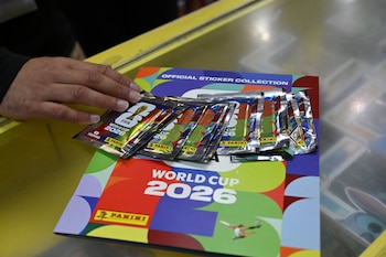 Una persona muestra paquetes de cromos y el álbum del Mundial 2026.