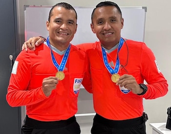 Árbitros salvadoreños posan con medallas y uniforme oficial de FIFA, tras recibir un reconocimiento por su labor durante el año 2024 (Foto cortesía El Gráfico).