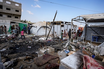 Palestinos inspeccionan los daños causados por un bombardeo israelí contra un campamento ubicado en el patio del Hospital Mártires de Al Aqsa (AP Foto/Abdel Kareem Hana)