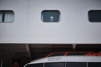 Un pasajero mira por la ventana del crucero Ambition, atracado en Burdeos. (Guillaume Pinon/EFE/EPA)