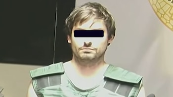 Un hombre con cabello castaño y barba corta viste un chaleco verde y lleva una barra negra sobre los ojos
