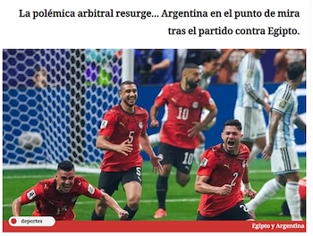 Jugadores de fútbol con camisetas rojas y pantalones negros en primer plano y otros con camisetas celestes y blancas al fondo en un campo con red de portería
