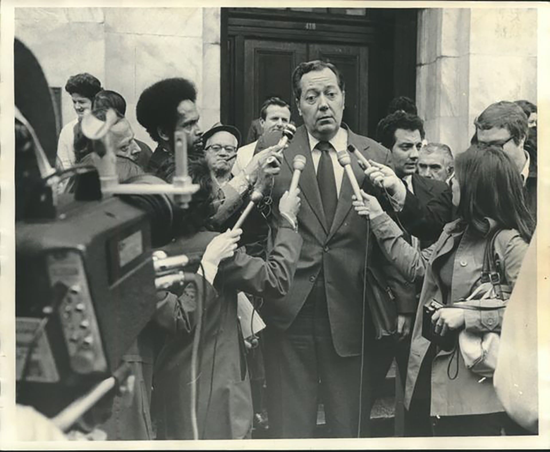 Garrison rodeado por periodistas y cámaras de televisión en las escalinatas de los tribunales de Nueva Orleans durante el transcurso de su investigación sobre el magnicidio de Dallas (The Times-Picayune/NOLA)