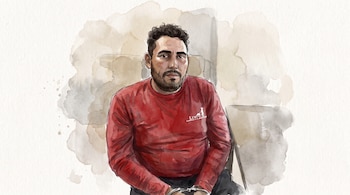 Ilustración de hombre con cabello oscuro rizado y barba, camiseta roja, esposado en las muñecas, sentado frente a un fondo abstracto beige y gris.