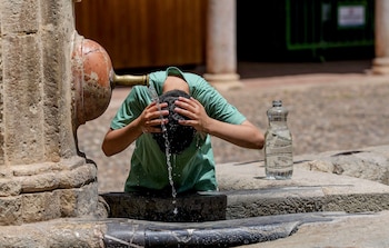Un turista se refresca en una fuente en Córdoba este lunes. (Rafa Alcaide/EFE)