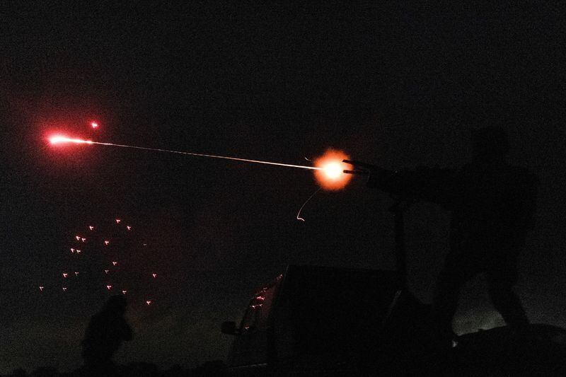 Miembros de una unidad móvil de voluntarios de defensa aérea disparan una ametralladora y un rifle de asalto para derribar un vehículo aéreo no tripulado durante un masivo ataque con drones rusos, en la región de Kiev (REUTERS/Stanislav Kozliuk)