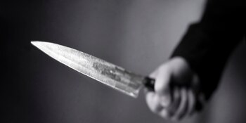 Hand wielding a menacing knife