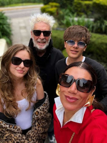 Cuatro personas posan sonrientes al aire libre para una autofoto mientras llevan gafas de sol y ropa de abrigo