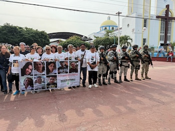 Personas que buscan a migrantes desaparecidos a finales de 2024 a lo largo de una ruta marítima de contrabando hacia Estados Unidos posan con fotos de sus seres queridos desaparecidos en Mazatán, estado de Chiapas, México, el sábado 9 de mayo de 2026. (AP Foto/Edgar H. Clemente)