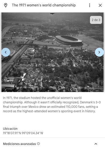 Fotografía aérea en blanco y negro de un gran estadio rodeado por carreteras, edificios, casas y áreas con vegetación