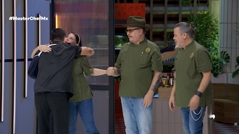 Un hombre vestido de negro abraza a una mujer junto a dos hombres con filipinas verdes en un estudio de televisión