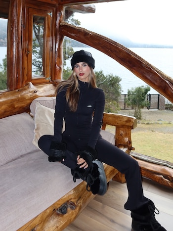 Con look total black, Poggio posó desde el interior de la cabaña con vista al lago