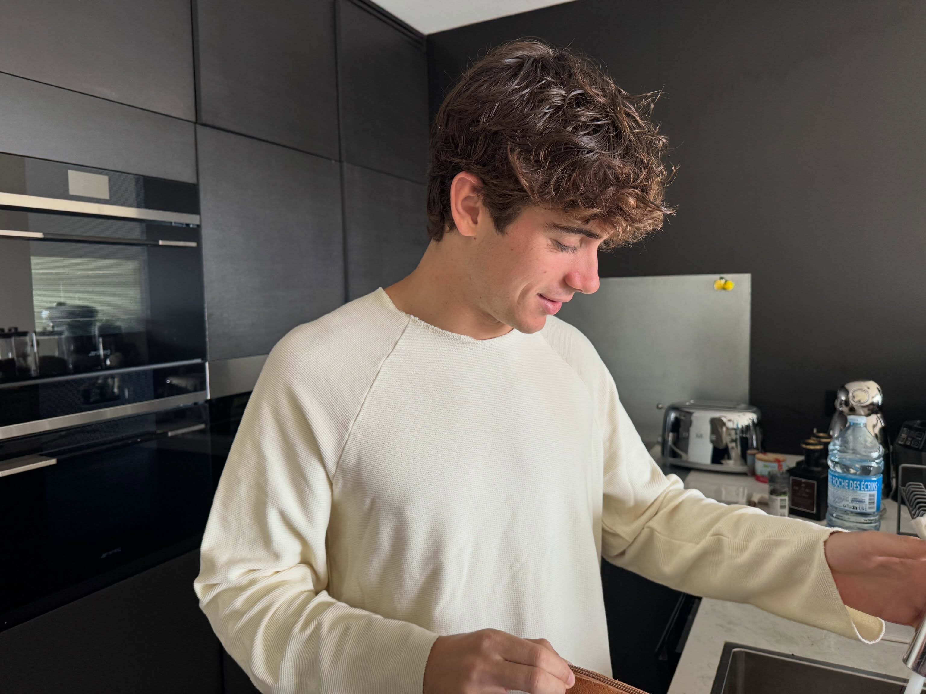 Franco Colapinto en la cocina de su alojamiento en Italia, con el buzo que le robaron junto al resto de sus pertenencias