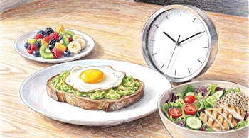 Plato de frutas con kiwi, bayas y plátano, tostada de aguacate con huevo frito, ensalada con pollo, quinua y verduras, y un reloj en mesa de madera.