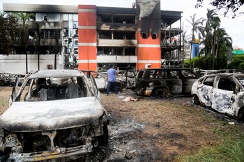Un hombre camina afuera de la oficina del fiscal departamental de Santa Cruz que fue incendiada durante la noche, en Santa Cruz, Bolivia, el jueves 29 de diciembre de 2022. (AP Foto/Ipa Ibanez)