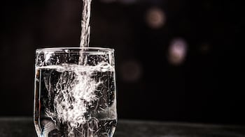 Personas bebiendo agua caliente en un entorno relajado, destacando la falta de respaldo científico para sus supuestos beneficios