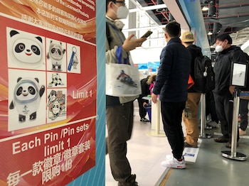 People wait in line at the souvenir shop, where Bing Dwen Dwen mascot merchandise is largely sold out, at the 2022 Beijing Olympics media center in Beijing, China, February 13, 2022. REUTERS/Jonathan Ernst